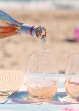 Rose being poured into glass at the beach