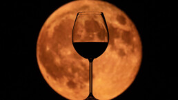 Photo of a wine glass in front of the moon
